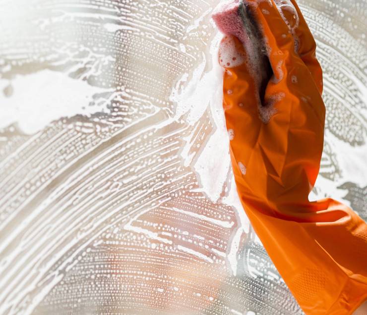 close-up-cleaning-window-with-sponge